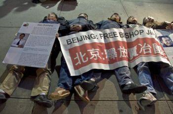 Demonstranter från Democratic Forum of China ligger draperade i en banderoll över sig vid det kinesiska konsulatet i New York i protest mot det kinesiska kommunistpartiets 60 år i makt, den 30 september 2009. (Aloysio Santos / The Epoch Times)
