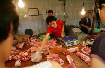 En försäljare säljer fläsk på en köttmarknad i Xian i Shaanxiprovinsen. Ett storskaligt utbrott av svinpest i Zhejiangprovinsen under de senaste två månaderna har ignorerats av ansvariga ämbetsmän enligt lokalbefolkningen. (China Photos/Getty Images)