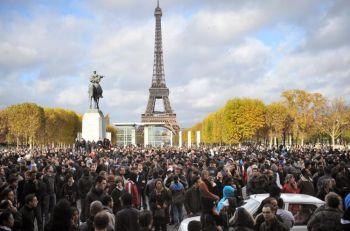 En hop människor samlades utan för Eiffeltornet lördagen den 14 november för att invänta en utlovad utdelning av pengar från det franska marketingföretaget Mailorama. Totalt var det 5000 brev med innehåll på mellan 5 till 500 euro styck som utlovats. (foto: Lionel 
