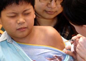 En pojke vaccineras mot influensaviruset. (AFP)