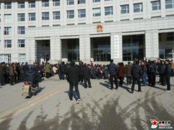 Över tusen invånare från två byar i Zhuanghe i Liaoningprovinsen i nordvästra Kina, stod på knä utanför stadshuset den 13 april och krävde att få träffa borgmästaren. (Foto: we54.com)
