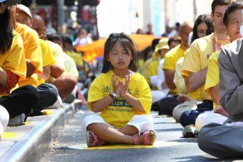 En ung kinesiska mediterar nära Times Square på lördagen under en uppvisning av Falun Gongs övningar. (Foto: The Epoch Times)

