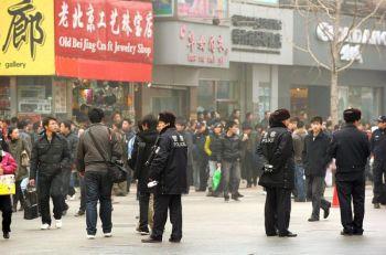 Poliser vaktar längs shoppinggatan Wanfujing i Peking efter att demonstranter samlats den 20 februari. Meddelanden på internet hade uppmanat missnöjda kineser att samlas på offentliga platser i 13 större städer för att att uppmärksamma "jasminrevolutionen" i mellanöstern.  (Foto: Peter Parks/AFP/Getty Images)