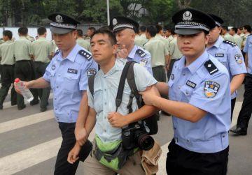 Kinesisk polis för bort en nyhetsfotografen, Felix Wong från Hong Kong, som fotograferat människor utanför Olympiska Stadion i Peking den 25 juli, 2008. (Foto: Mark Ralston/AFP/Getty Images)