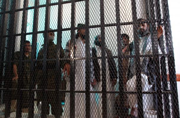 Misstänkta militanta muslimer från al-Qaida står bakom galler och framför sina domare under en utfrågning i en domstol den 2 december 2014 i Jemens huvudstad Sanaa. Domstolen som är specialiserad på terroristmål dömde sju åtalade till mellan två och fyra års fängelse för kopplingar till al-Qaida, och frikände en åttonde person. (Foto: Mohammed Huwais/ AFP/Getty Images)
