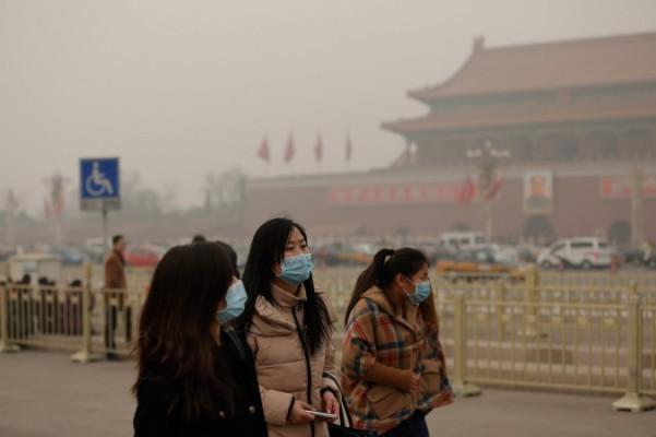 Människor promenerar med andningsmasker på Himmelska fridens torg i Peking under en dag med svåra föroreningar, den 25 februari 2014. Akutmottagningarna har varit överfulla med patienter med andningsbesvär. (Foto: Lintao Zhang/Getty Images)
