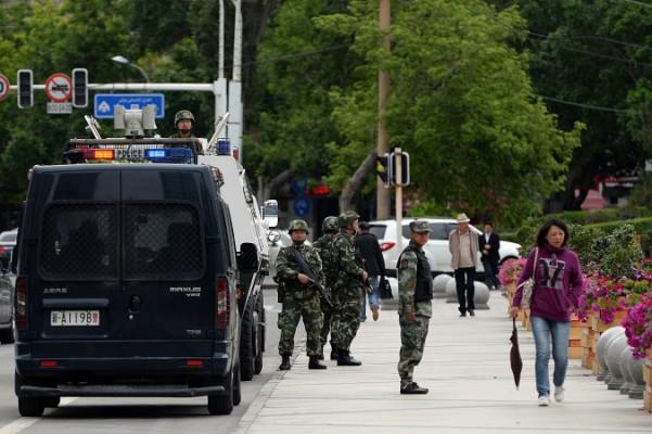 Beväpnade kinesiska paramilitära poliser vaktar en gata i Urumqi i Xinjiangprovinsen, där minoritetsfolket uigurer bor, den 23 maj 2014. Våld och gripanden i Xinjiang har fortsatt under Ramadan, med över hundra, kanske till och med tusentals döda i Kashgar på den sista dagen av den heliga månaden. (Goh Chai Hin/AFP/Getty Images)