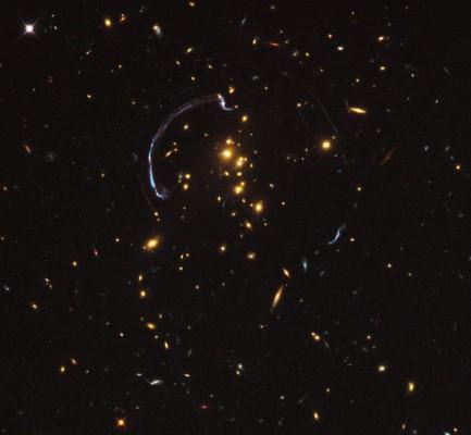 En avlägsen galax, nästan 10 miljarder ljusår bort, tycks vara insvept i en närmare 90 graders ljusbåge i galaxklustret RCS2 032727-132623. (Foto från NASA, ESA, J. Rigby/NASA Goddard Space Flight Center, K. Sharon/Kavli Institute for Cosmological Physics, University of Chicago)
