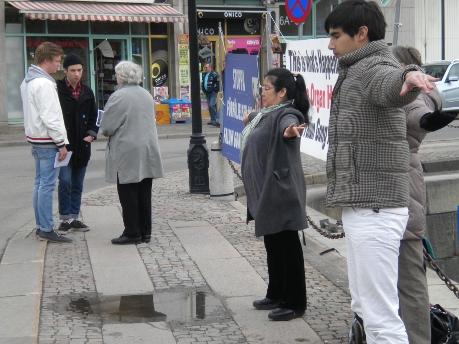 Framför det kinesiska konsulatet i Göteborg passerar två unga män den 25 april. Medan de får höra om vad som hände kinesiska Falun Gong-utövare i Peking denna dag för fjorton år sedan, håller stadens Falun Gong-utövare en tyst och stilla manifestation. (Foto: Barbro Plogander, Epoch Times)
