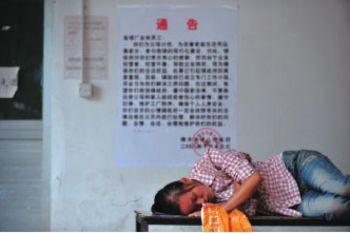 En arbetare sover på en bänk i väntan på sin lön. The Hong Kong Smart Union Group, en av världens största leksakstillverkare, har stängt två fabriker i Guangdongprovinsen och friställt 6500 anställda. (Foto: Getty Images)
