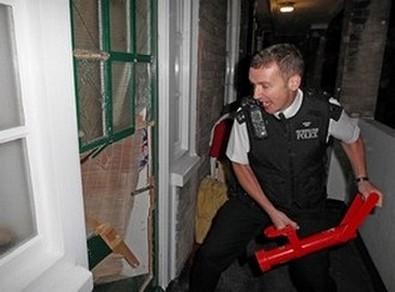 En polis slår in en dörr vid en raid i ett hus i anslutning till upploppen i London i augusti 2011. Extrem fysisk ansträngning kan påverka polisers minnen från händelser, enligt en ny studie. (Foto: Nigel Howard/AFP)