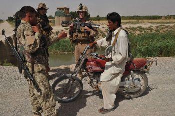 Marinsoldater från 3:e bataljonen, 9:e Kodiakkompaniet kontrollerar identiteten på en afghansk lokal polis (ALP) eller Arbaki i Kote Tazagul området i Marjahdistriktet, Helmandprovinsen i maj. (Foto: Massoud Hossaini/AFP/Getty Images)