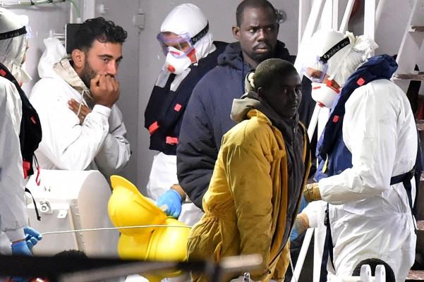 Den tunisiske skepparen Mohammed Ali Malek (t. vänster) står på däck på den italienska kustbevakningens fartyg Gregoretti som transporterade de 27 överlevande från skeppsbrottet i Medelhavet till Catania, Italien, den 20 april 2015. Den tunisiske skepparen greps och misstänks för ha orsakat olyckan. Hans syriska besättningsmedlem Mahmud Bikhit greps också. (Foto: Tullio M. Puglia / Getty Images) 