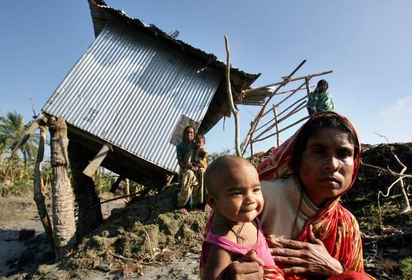 Kvinnor och barn framför en förstörd affär i byn Boroitola på den södra delen av Bangladeshs kust. Otaliga människor är nu i akut behov av mat och vatten. (Foto: AFP/Jewel Samad)
