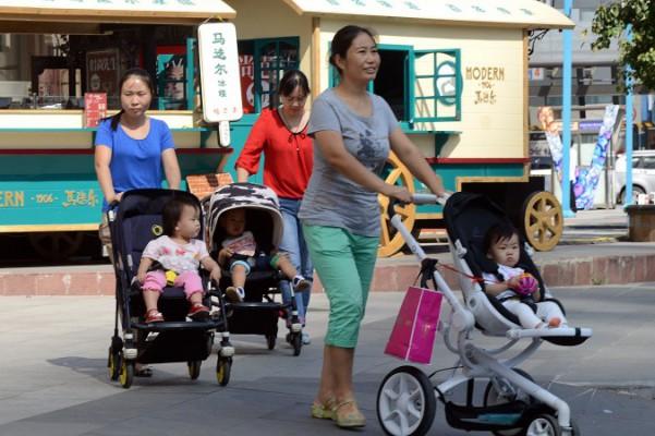 En grupp kinesiska kvinnor tar sina barn på en promenad utanför ett köpcentrum i Peking den 18 oktober 2014. Kinas könskvot för nyfödda år 2014 var 115,88 pojkar på 100 flickor, vilket är högst i världen, enligt statliga Xinhua. (foto: Goh Chai Hin/ AFP/ Getty Images)