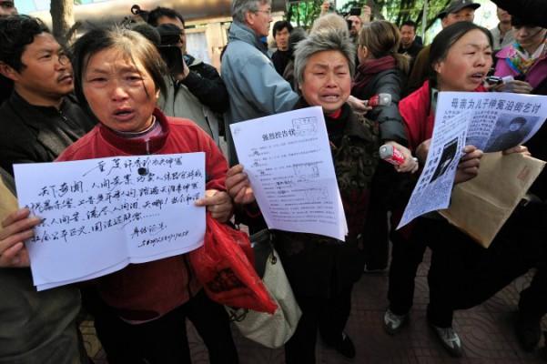 Kinesiska petitionärer visar upp dokument om sina fall i Peking. Nyligen bröt sig ett antal lokala petitionärer in i ett så kallat svart fängelse för att rädda en annan petitionär som hölls illegalt inspärrad av myndigheterna. (Teh Eng Koon/AFP/Getty Images)