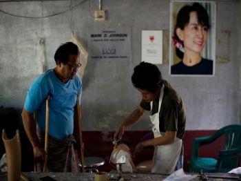 En burmesisk man som fallit offer för en landmina ser på när en arbetare gör i ordning en protes vid Mae Tao-kliniken i nordvästra Thailand. (Foto: Nicolas Asfouri/AFP/Getty Images)