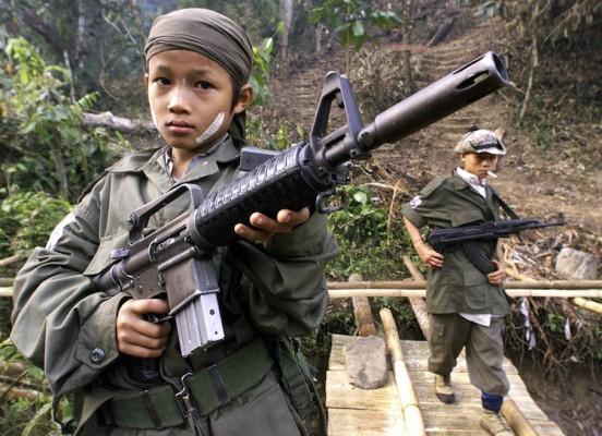 Beväpnade barnsoldater från Karen National Unions rebellarmé firar den 51:a årsdagen av arméns revolt mot juntan i Tak nära gränsen till Thailand den 31 januari 2000. (Foto: Pornchai Kittiwongsakul /AFP/Getty Images)
