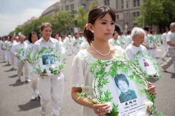 Falun Gong-utövare håller upp bilder på offren för förföljelsen under en parad i Washington den 18 juli 2011. (Foto: Epoch Times)
