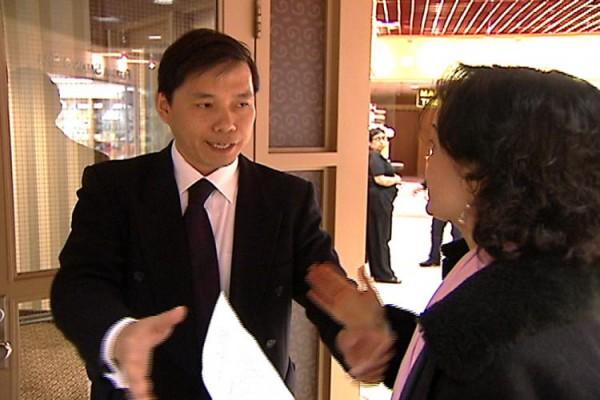 Arrangören visade ut reportern Danielle Zhu (till höger) från presskonferensen. Personen identifierades senare som Torontos generalkonsul Lu Kun. Zhu håller i inbjudan från det kinesiska konsulatet. (bild från utsändning från Tang Dynasty Television)