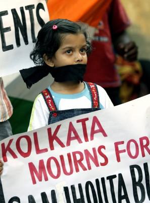 En indisk flicka håller ett plakat när hon deltar i kondoleansmöte i Kolkata i Indien den 19 februari 2007 efter att två bomber sprängdes på ”Vänskapsexpressen” mellan Pakistan och Indien. (Foto: AFP/ Deshakalyan Chowdhury)
