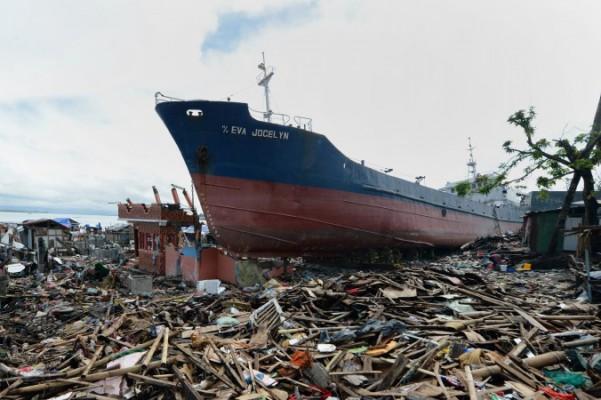 Ett lastfartyg som sveptes i land av supertyfonen Haiyan ligger fortfarande kvar bland bråten i den förstörda kuststaden Tacloban den 24 december 2013. (Foto: Ted Aljibe / AFP / Getty Images)
