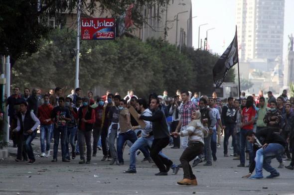 Egyptiska demonstranter kastade stenar mot kravallpolisen under sammandrabbningar på Tahrirtorget, Kairo, 25 november. President Mohamed Morsi försökte på söndagen lugna ner protesterna mot den nya förordningen som ger ökad makt åt presidenten. (Foto: Gianluigi Guercia /AFP/ Getty Images)