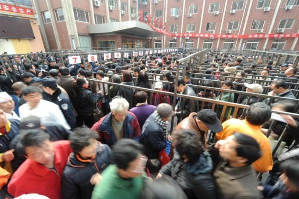 Folk köar i Peking för att få bättre placering på väntelistan till nya lägenheter efter att den lokala regeringen meddelat att man kommer att demolera den gamla centrala delen i Pekings västra förort. (Foto: AFP)