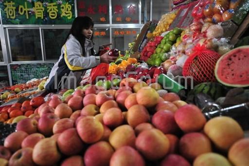 En kvinna väljer bland frukterna på en marknad i Peking. (Foto: Frederic J. Brown/AFP) 
