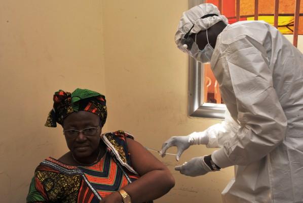 En kvinna blir vaccinerad den 10 mars 2015 på en vårdcentral i Conakry under de första kliniska prövningarna av vaccinet rVSV EBOV mot ebolaviruset. Kliniska prövningar lanserades den 7 mars 2015 i Guinea som det sista steget innan vaccinet finns på marknaden. (Foto: Cellou Binani/ AFP /Getty Images)