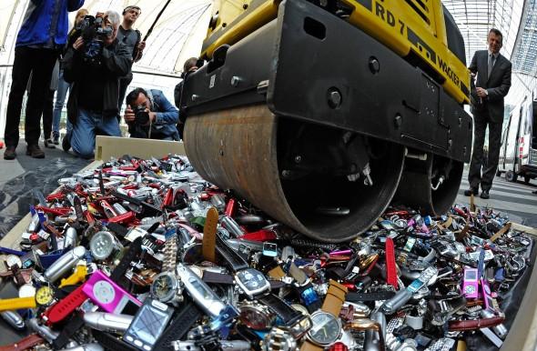 Tullen använder en vält för att förstöra förfalskade MP3-spelare och klockor på flygplatsen i München, den 22 april 2010. (Foto: Joerg Koch/AFP/Getty Images)