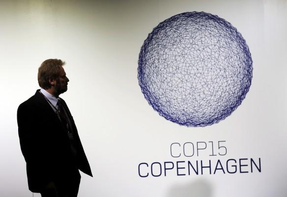 En besökare tittar på konferenslogon vid ingången till Bella Center där Köpenhamns klimatkonferens hålls den 8 december 2009. (Foto: AFP/Adrian Dennis)