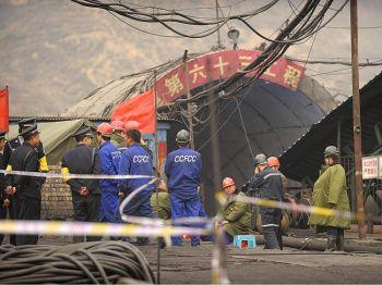 Gruvarbetare och polis vid ingången till kolgruvan Wangjialing i Kina. 115 arbetare drogs ut levande från den översvämmade gruvan i Shanxiprovinsen den 7 april 2010. (Foto: Peter Parks / AFP / Getty Images)