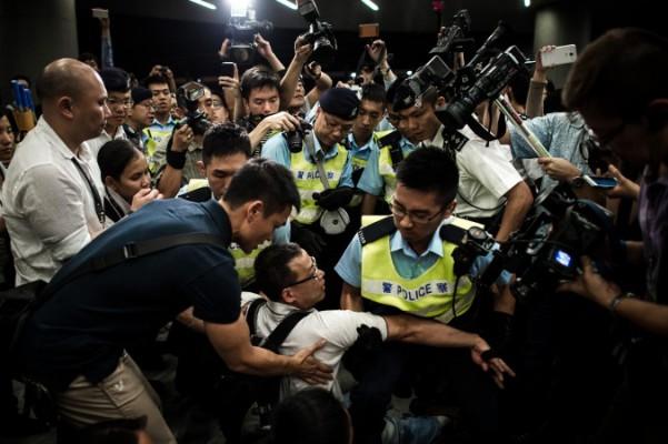 Kravallpolis för bort demonstranter från det lagstiftande rådets byggnad i Hongkong, den 14 juni, 2014. Protesterna mot en regional utvecklingsplan urartade i en attack mot rådets byggnad, som flera nu misstänker iscensattes av provokatörer från Kinesiska kommunistpartiet. (Foto: Philippe Lopez/AFP/Getty Images)
