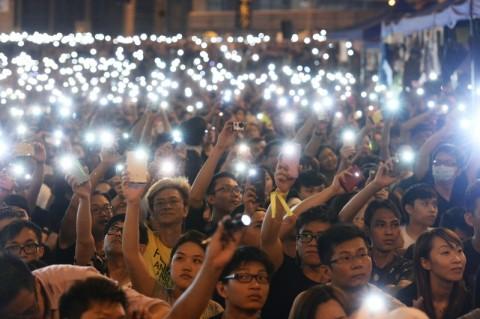 Ett stort antal prodemokratiska Hongkongbor håller upp sina telefoner mot natthimlen i Hongkong den 4 oktober. (Foto:Song Xianglong/Epoch Times)
