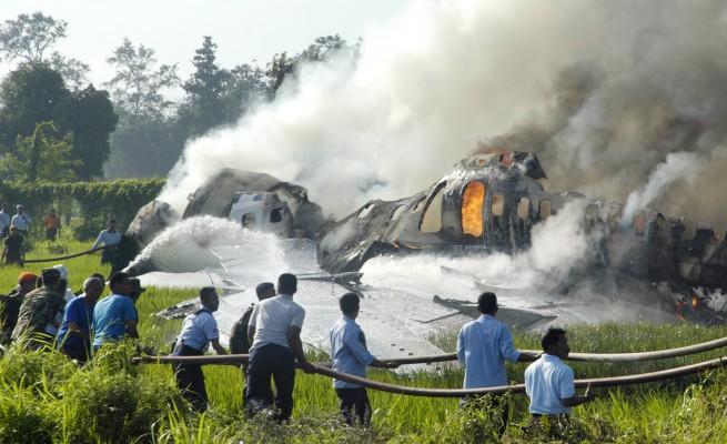 Räddningsarbetare försöker släcka lågorna på en Boeing Garuda 737-400 jet på Yogyakarta flygplats, den 7 Mars 2007. Många passagerare och besättningsmedlemmar kunde inte ta sig ur planet som började brinna vid landning och omkom. På planet fanns flera australiska diplomater och journalister. (Foto: AFP/Tarko Sudiarno)