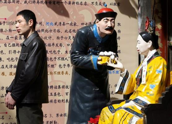 En fotgängare passerar två statyer från Qindynastin (Foto: AFP/The Eng Koon)