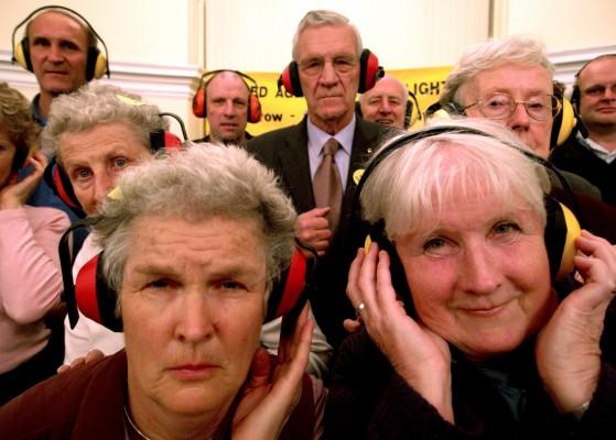 En grupp människor skyddar sina öron vid en kampanj mot bullerstörningar från Heathrow flyplats i London. För att förebygga tinnitus är det viktigt att inte utsätta öronen för alltför höga ljud. Man bör använda hörselkåpor om man går på konserter eller andra evenemang där ljudet är högt. (Foto: AFP/ MaxNash)