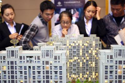 Presumtiva bostadsköpare tittar på modeller av lyxlägenheter. Situationen för Kinas fastighetsmarknad går i två rakt motsatta riktningar: Wenzhou i Zhejiangprovinsen och Ordos i Inre Mongoliet, upplever betydande prisfall, medan trenden i de största städerna är den motsatta. (Foto: AFP/Getty Images)