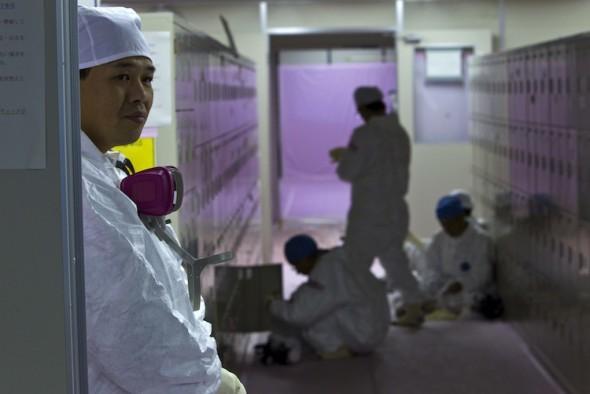 Japanska arbetare i skyddsdräkter vid sina förvaringsskåp inne i nöddriftcentralen vid kärnkraftverket Fukushima Daiichi i Okuma den 12 november 2011. (Foto: David Guttenfelder / AFP / Getty Images)
