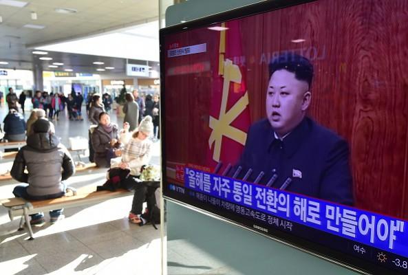 Resenärer i Sydkoreas huvudstad Seoul sitter bredvid en tv-skärm som visar Nordkoreas ledare Kim Jong Uns nyårstal den 1 januari 2015. Länderna har haft vapenvila sedan 1953 men ligger fortfarande i fejd med varandra. Foto: Jung Yeon-Je /AFP/ Getty Images