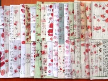 Namninsamling med kinesiska underskrifter på. Förutom sina namn tryckte många dit sina tumavtryck. 