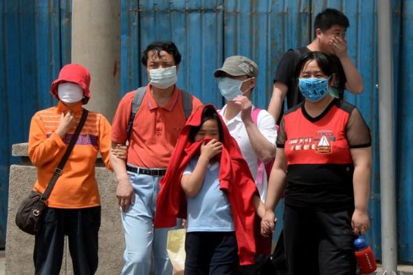 Människor bär masker för att skydda sig mot luftföroreningar och damm i Peking den 19 maj 2013. (Foto: Mark Ralston / AFP / Getty Images)