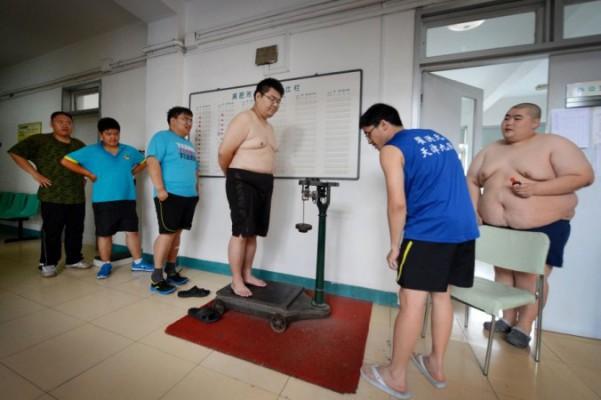 Överviktiga människor kollar sin vikt efter akupunktur och behandling på ett sjukhus i Tianjin i Kina. (Foto: Mark Ralston/AFP/Getty Images)