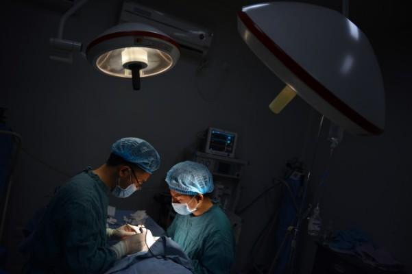 Två läkare opererar i Chongqing i sydvästra Kina den 9 augusti 2013. En patient fick både matchande lever och njure för transplantation på bara en månad i staden Tianjin, enligt New Tang Dynasty Television. (Foto: Peter Parks/ AFP/Getty Images) 
