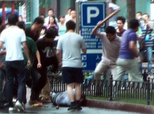 Bilden är en Tv-bild  från AFP. Hankineser attackarerar en ensam uigurisk man på en gata i Urumqi, Xinjiang den 8 juli. Grupper av hankineser attackerade två muslimska uigurer i separata incidenter i Urumqi under gårdagen enligt AFP reportrar, som bevittnade händelserna. (Foto: Sam Beattie/AFP /AFPTV) 