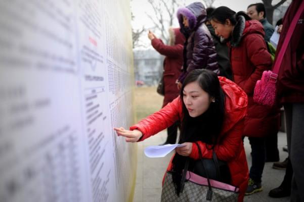 Studenter kollar upp rumsnummer för de nationella inträdesproven vid ett universitet i Peking den 4 januari till 2014. Att kinesiska studenter fuskar genom att anställa skribenter som skriver uppsatserna för dem, är ett utbrett problem både i Kina och utomlands, enligt rapporter. (Foto: Wang Zhao/AFP/Getty Images)

