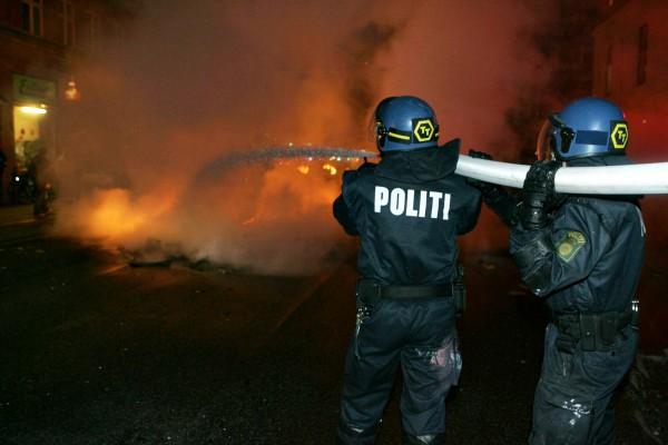 Polisen släcker en eld i en brinnande kontainer nära Ungdomshuset vid Nörrebro i Köpenhamn, den 1 mars 2007. (Foto: AFP / Jens Nørgaard Larsen)