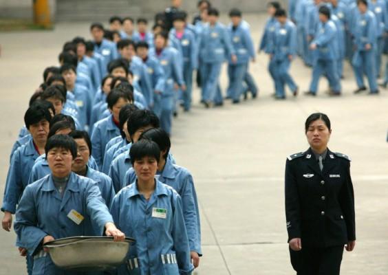 Fångar går med en poliseskort under ”öppet hus” i ett fängelse i Nanjing 2005. Kraven på avskaffandet av regimens arbetslägersystem tilltar i Kina. (Foto: STR/AFP/Getty Images)