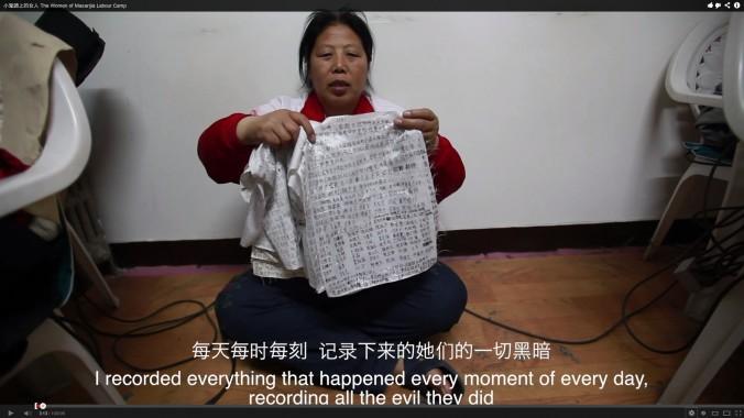 Liu Hua håller upp dagböckerna om tortyr och övergrepp som hon hade smugglat från arbetslägret. Efter att ha sagt den repliken som visas i undertiteln på den här bilden, sade hon: "Och hade kvinnorna att smuggla ut dem i deras underliv." (Skärmdump via Epoch Times)
